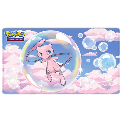 Mew Mythical Foil Playmat sett ovenfra: Mew i en såpeboble på rosa skyer og blå himmel